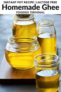 three jars filled with homemade gheee sitting on top of a wooden cutting board