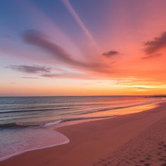 the sun is setting at the beach with footprints in the sand