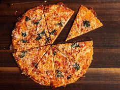 a sliced pizza sitting on top of a wooden table