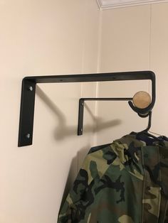 a jacket hanging on a coat rack next to a wall with a ball in it