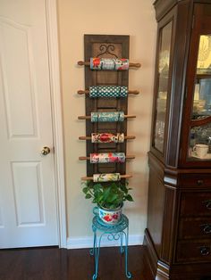 a potted plant sitting on top of a blue stool next to a wooden shelf