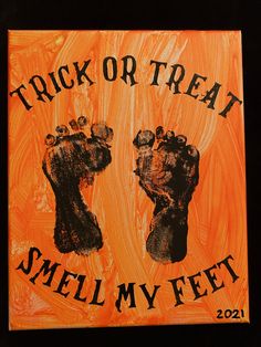 an orange and black sign with two hands on it that says trick or treat smell my feet