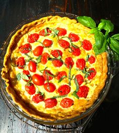 a pie with tomatoes and basil on top