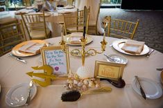 there is a table set up for a wedding reception with place settings on the table