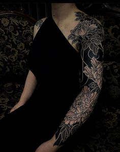 a woman with tattoos on her arm sitting in a chair