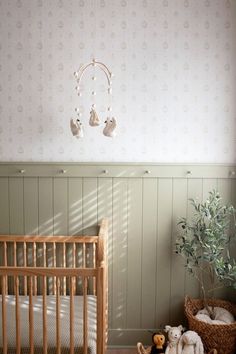 a baby crib with two stuffed animals next to it and a potted plant