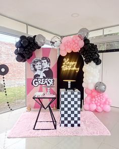 a party setup with balloons and decorations for a birthday or baby shower in pink, black and white