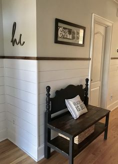 a black bench sitting in the corner of a room next to a white painted wall