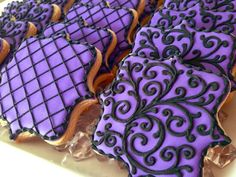 purple and black decorated cookies sitting on top of each other