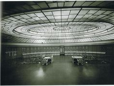 the inside of a building with tables and chairs in front of windows on each side