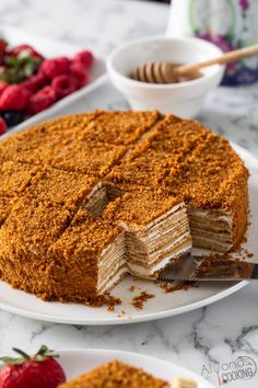 there is a cake that has been cut into pieces and served on plates with strawberries