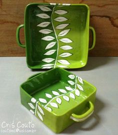 two green dishes sitting on top of a white counter next to each other with leaves painted on them