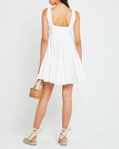 a woman wearing a white dress and sandals Cotton Sundress For Daywear, Cotton Mini Dress For Vacation, Cotton Mini Sundress For Day Out, Chic Cotton Sundress Mini Length, Chic Cotton Sundress, Chic Cotton Sundress For Casual Days, Chic Cotton Sundress For Casual Occasions, Chic Cotton Sundress For Casual Wear, Daytime Cotton Dress With Ruffles