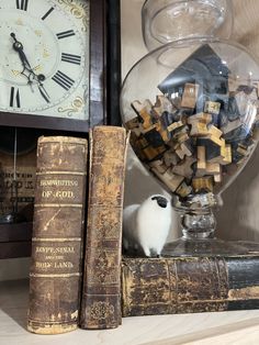 an old clock and some books on a shelf