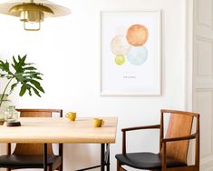 a dining room table with two chairs and a potted plant on the table in front of it