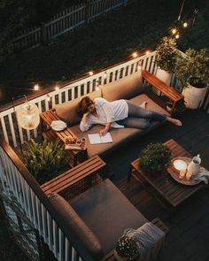 a woman laying on top of a couch in the middle of a patio at night