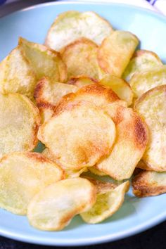 a blue plate topped with fried potatoes on top of a table