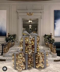 a large group of christmas presents sitting on top of each other in front of a staircase