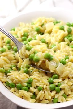 a white bowl filled with pasta and peas