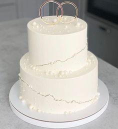 a wedding cake with two rings on top