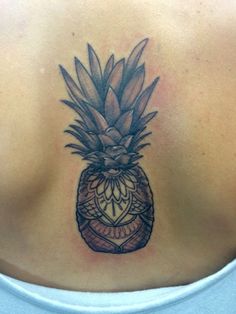 a woman with a tattoo on her back has a pineapple in the shape of a heart