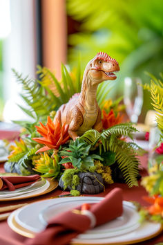 a dinosaur figurine sitting on top of a table next to plates and napkins