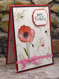 a handmade birthday card with a red flower on it and a pink ribbon around the edge