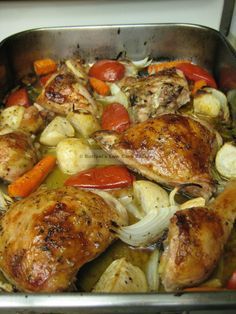 a pan filled with chicken, onions and carrots on top of a stovetop