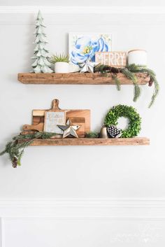 two wooden shelves decorated with christmas decorations and greenery, one is holding a wreath