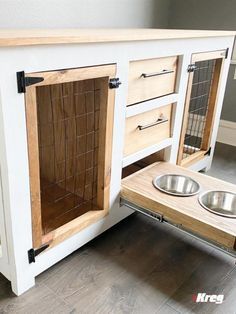 a dog house built into the floor with two bowls on it's bottom shelf