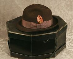 This listing is for a vintage Cavanagh Fedora style hat, size 7 1/8. Originally sold by Bill Taylor Hat Co. in Cleveland, Ohio. The hat doesn't appears to be used. The dark brown hat, with a light brown bow band is 1 5/8” high, and has a feather. The inside band has the initials perforated CWD. The gold logo is on the upper silk or satin part of the hat and Bill’s Taylor Co is on the sweatband inside on the hat in gold. There is no tag with the style name or the original price. The original Cava Formal Brown Felt Hat With Flat Bill, Brown Felt Hat With Flat Bill For Formal Occasions, Vintage Fedora For Kentucky Derby With Flat Bill, Vintage Brown Fedora For Formal Occasions, Brown Fedora For Kentucky Derby And Formal Occasions, Formal Brown Hat, Vintage Brown Felt Hat With Flat Bill, Vintage Brown Top Hat With Flat Bill, Vintage Brown Flat Bill Felt Hat