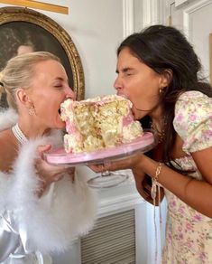 two women are sharing a piece of cake with each other in front of the camera