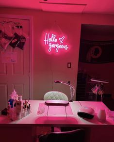 a desk with a neon sign above it that says hello gorgeous