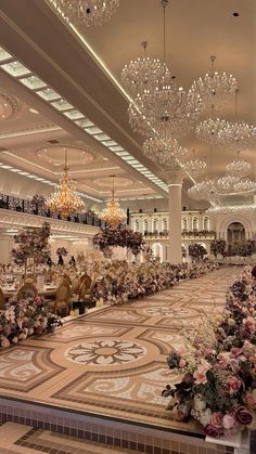 an elaborately decorated ballroom with chandeliers and flowers