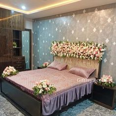 a bed sitting in a bedroom next to a dresser and flowers on top of it