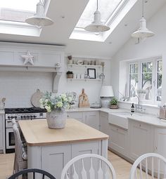 a kitchen filled with lots of white furniture