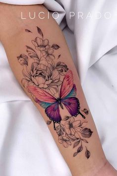 a woman's arm with a butterfly and flowers tattoo on the left side of her arm