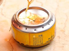 a yellow can filled with liquid sitting on top of a table