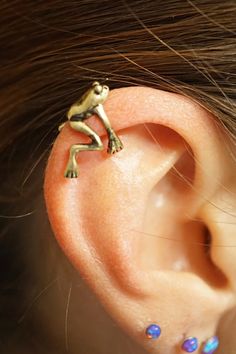 a close up of a person's ear with a frog on it