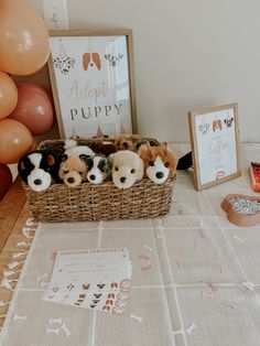 there are stuffed animals in a basket on the table next to some balloons and other decorations