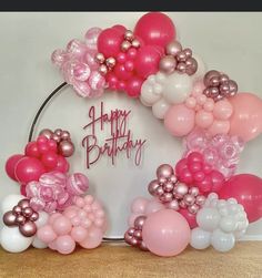 a happy birthday balloon arch with pink, white and silver balloons in the shape of a wreath