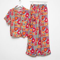 Our pajama sets are like wrapping yourself in a hug from your favorite auntie. With one-of-a-kind prints designed to represent, you'll slide into bed feeling like royalty. The top? Short-sleeved and just loose enough, because we know nobody's got time for feeling stuffy. And these pants – they've got that stretchy waistband, so go ahead and have that extra slice of pie, honey. Plus, pockets! Now, can we talk about this print? It’s a whole mood, showcasing the beauty and grace of Black women. Eve Slice Of Pie, Can We Talk, Fly Girl, A Hug, Tee Outfit, Pajama Top, Pajama Sets, Pj Sets, Tee Shop