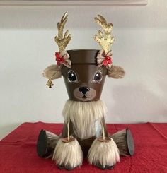 a brown and white reindeer cup sitting on top of a red table