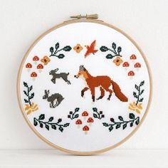 a cross stitch pattern with an orange fox and other animals