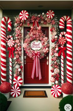 a christmas wreath with candy canes and decorations on the front door for an outdoor display