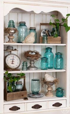 an old china cabinet is filled with glass jars and other things to decorate on it