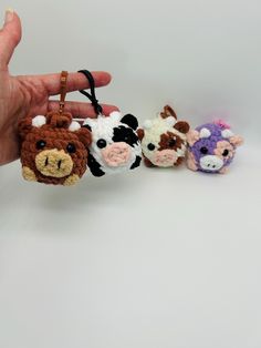 small crocheted animal keychains are being held by someone's hand