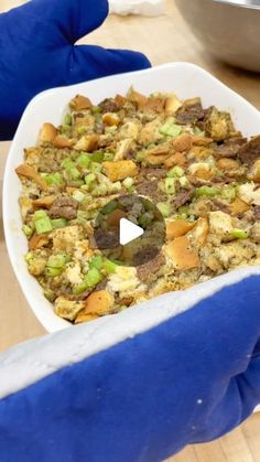 a bowl filled with food sitting on top of a table next to a blue glove