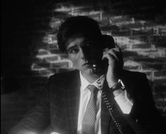 a man in a suit talking on a telephone