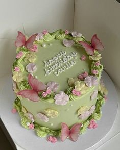 a green birthday cake with butterflies on it